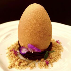 "Uovo nel nido di cioccolato", cioccolato al latte e arachidi, mouse al cioccolato e cuore al caramello mou
